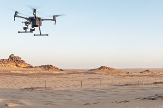Ein Mann in der Wüste steuert eine Drohne