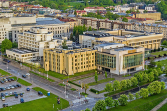 Luftaufnahme eines großen Häuserblocks. in der Mitte ein auffällig gelbes Gebäude