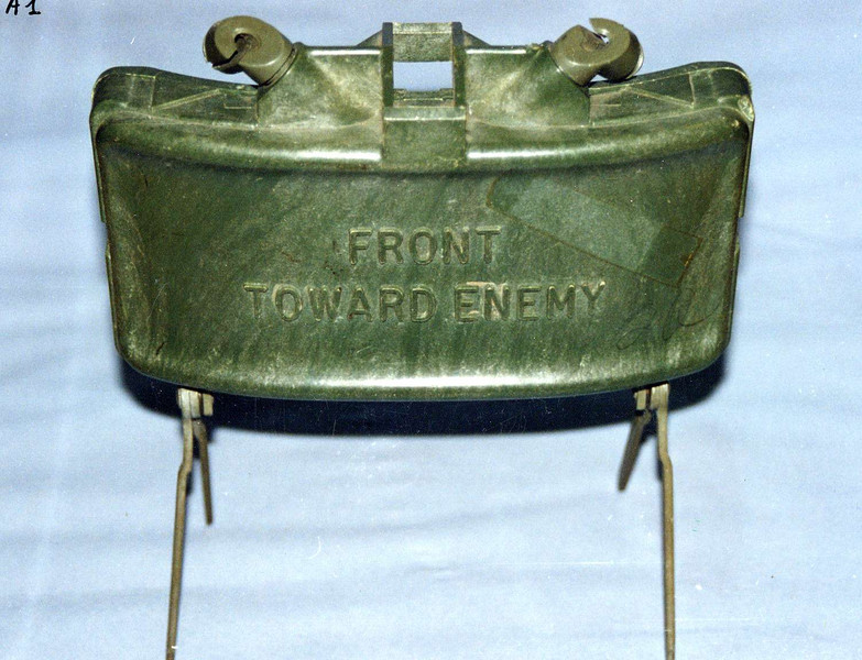 Die Claymore Mine hat ein gebogenes Metallgehäuse und steht auf vier filigranen Beinen.