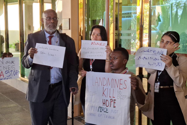 Vier Überlebende und ihre Schilder in Nahaufnahme: zum Beispiel: Landmines Kill Hope