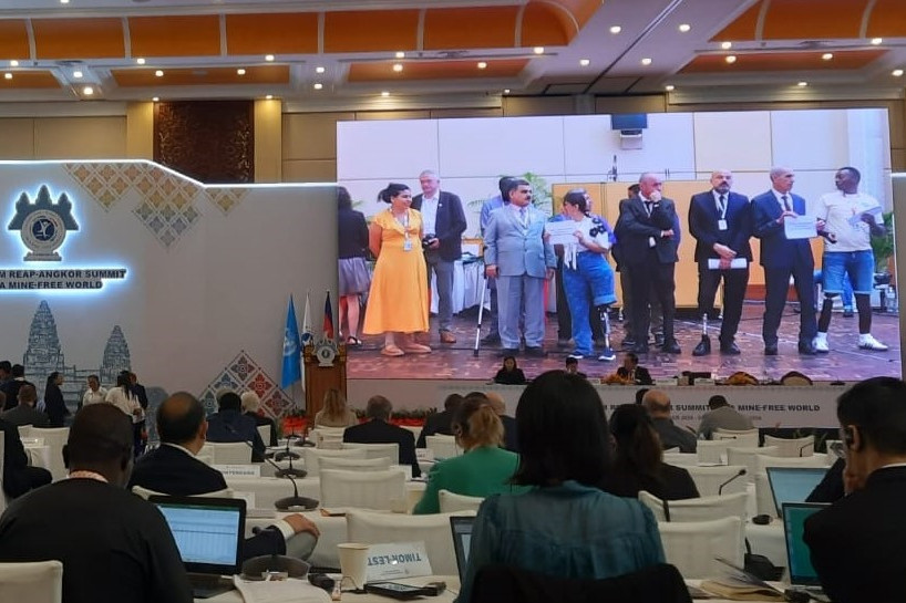 Gruppe von Überlebenden von Antipersonen-Minen während der abschließenden Statements der Überlebenden auf der Siemp-Reap-Konferenz werden auf einen Bildschirm in einem Konferenzraum projiziert.