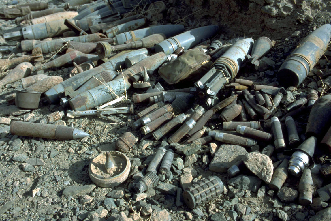 Mehrere metallische Gegenstände liegen auf sandig-steinigem Boden