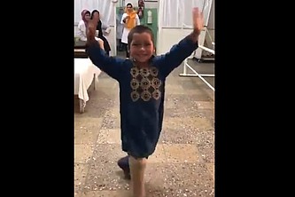 Ein kleiner Junge mit Prothese tanzt glücklich