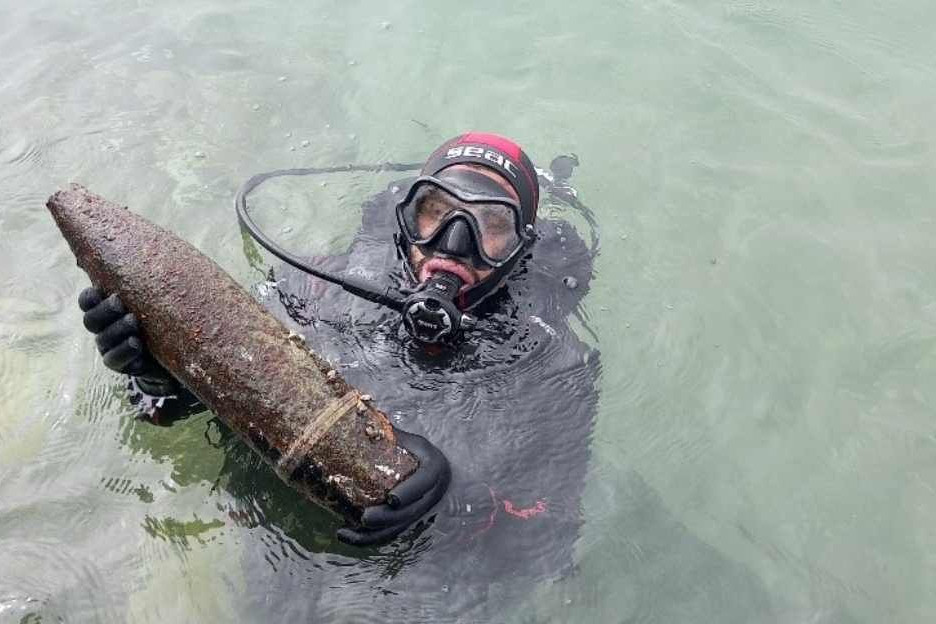 Einer der Taucher zeigt einen nicht explodierten Sprengkörper bei Rakka in Syrien. 